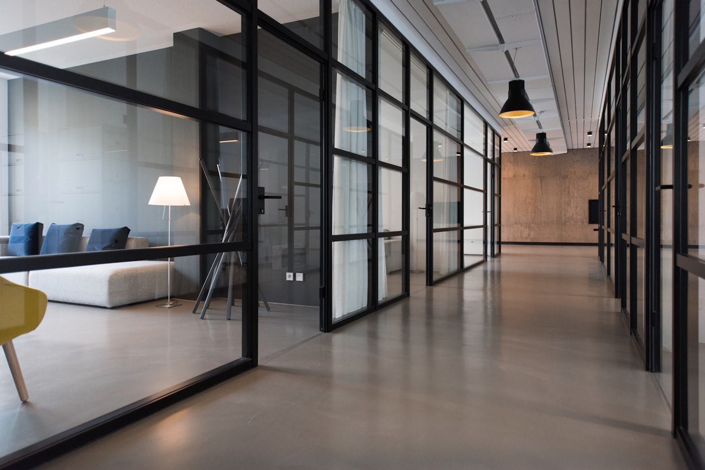 A bright modern law office corridor with glass partitions