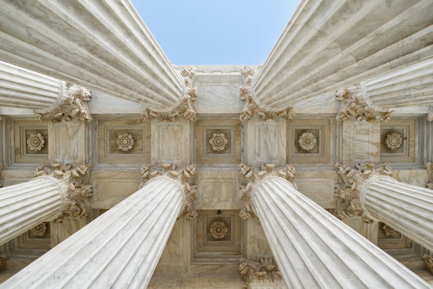 Classical stone columns of a courthouse seen from below