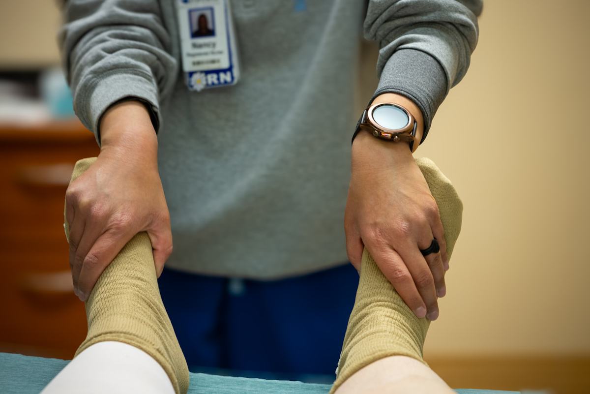 A therapist supporting the leg of a patient during rehabilitation