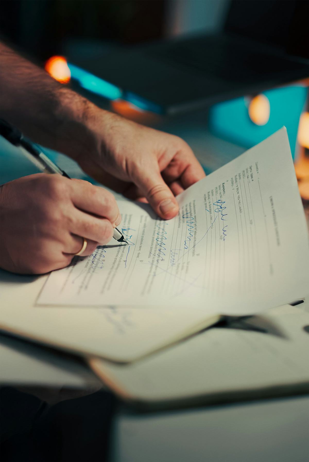 A person signing an insurance document with a pen